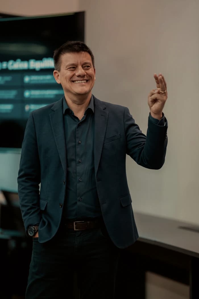 Rangel, da NØR, sorrindo durante uma apresentação, de blazer azul-escuro